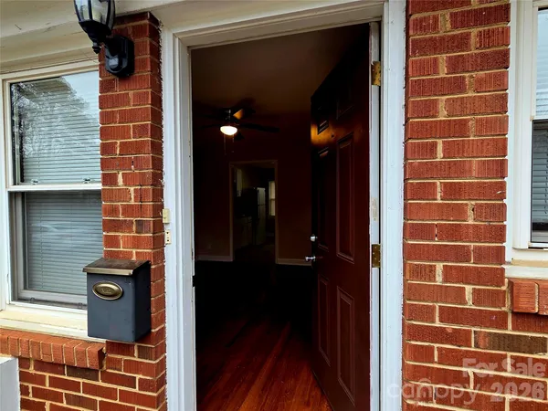 an empty room with wooden floor and a ceiling fan
