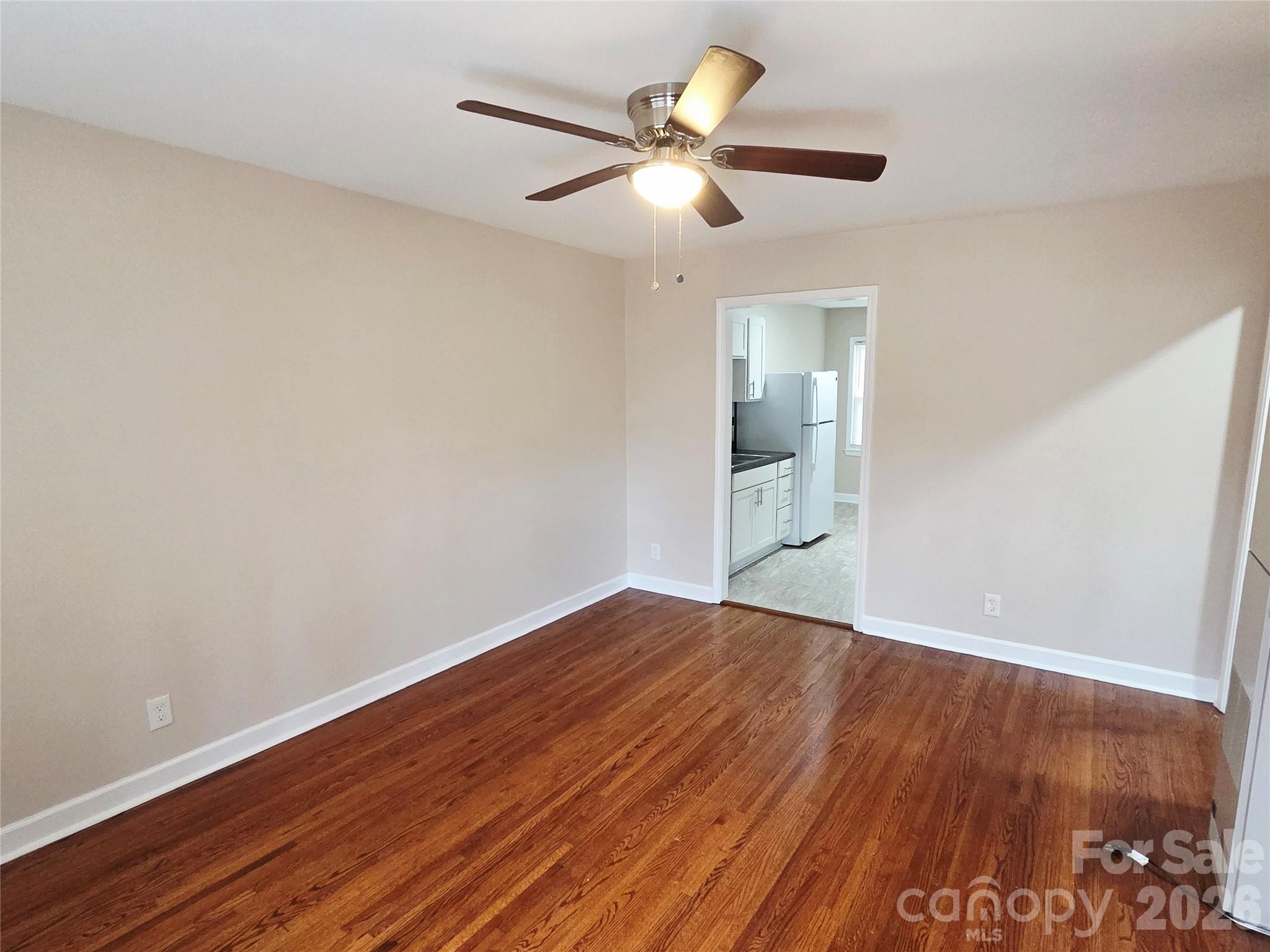 3500 North Sharon Amity Road Charlotte, NC 28212 - Photo 14 of 16 an empty room with wooden floor and a ceiling fan