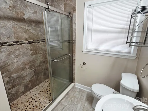 a bathroom with a toilet and a shower
