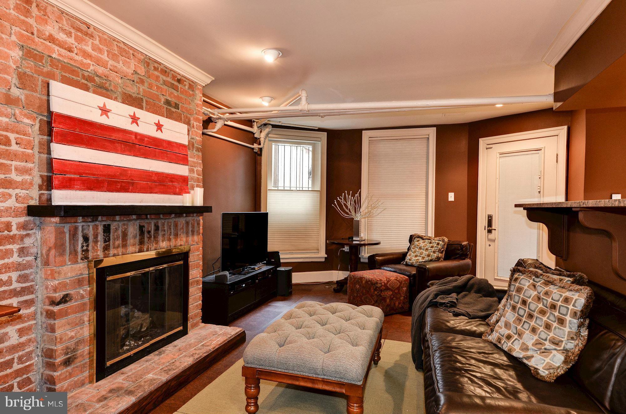 1733 Q Street Northwest Washington, DC 20009 - Photo 13 of 15 a living room with furniture a flat screen tv and a fireplace