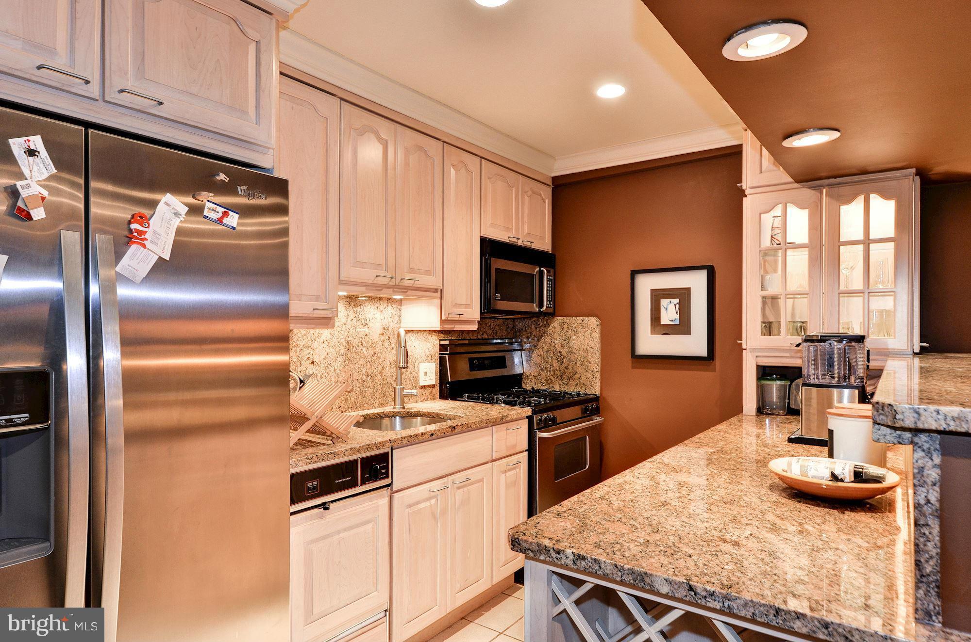 1733 Q Street Northwest Washington, DC 20009 - Photo 14 of 15 a kitchen with granite countertop kitchen island stainless steel appliances a stove a sink and a refrigerator