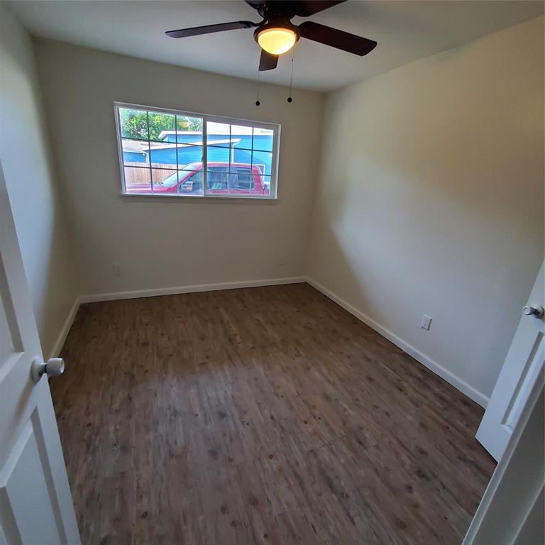 4205 Metropolitan Avenue Dallas, TX 75210 - Photo 4 of 6 an empty room with wooden floor and windows
