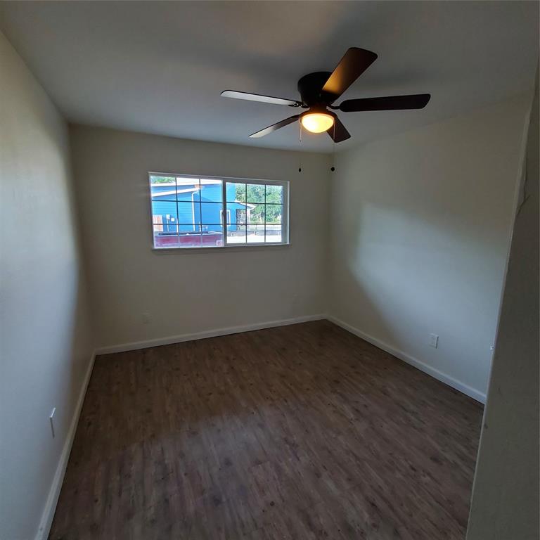 4205 Metropolitan Avenue Dallas, TX 75210 - Photo 6 of 6 an empty room with wooden floor fan and windows