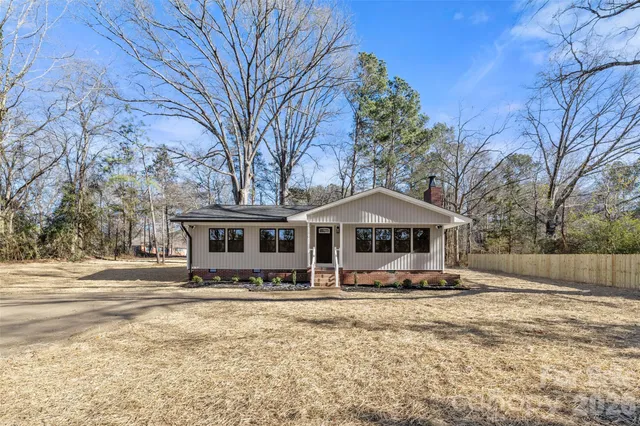 a front view of a house with a yard covered with snow
