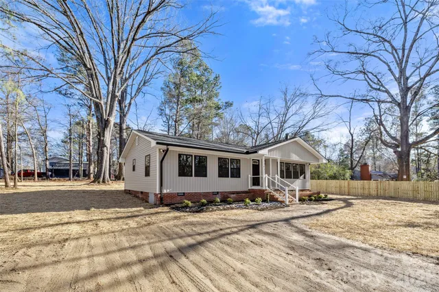 a front view of a house with a yard covered in snow