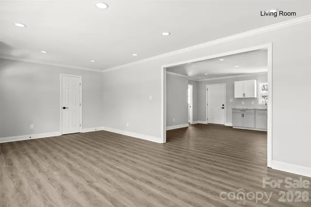 a view of an empty room with wooden floor and a cabinet