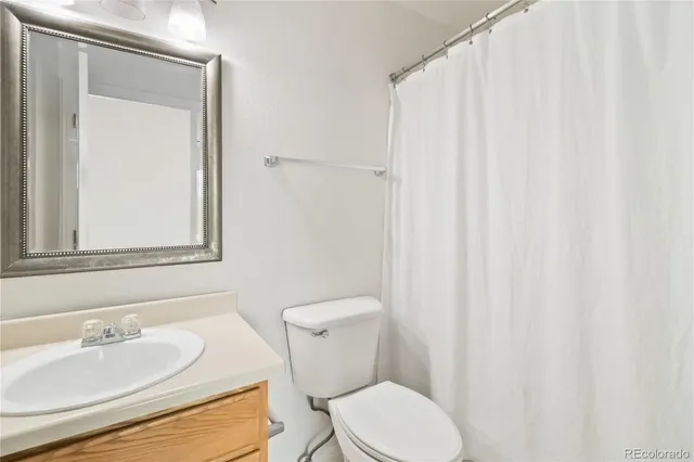 a bathroom with a toilet a sink and a mirror