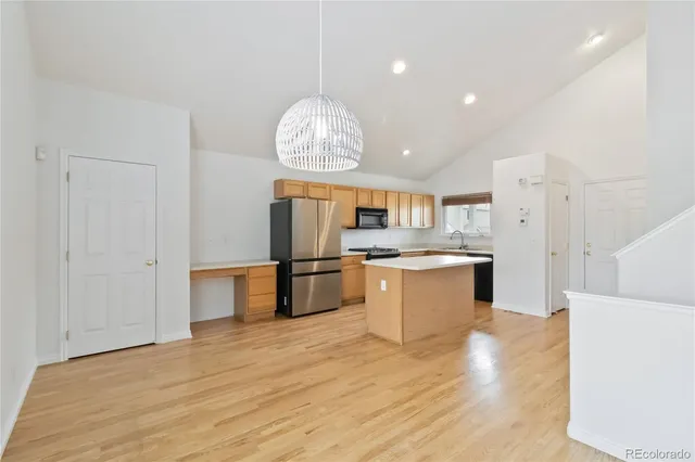 a kitchen with stainless steel appliances granite countertop a refrigerator and a stove top oven