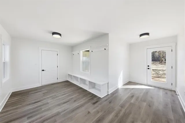 a view of empty room with wooden floor and ceiling fan