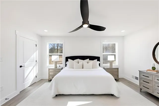 a spacious bathroom with double vanity sink a mirror and a toilet