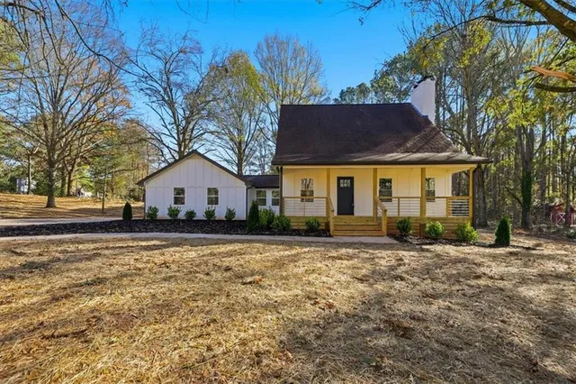 a front view of house with yard and trees in the background
