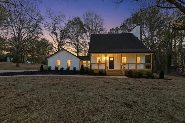 a view of a house with a large tree and wooden fence