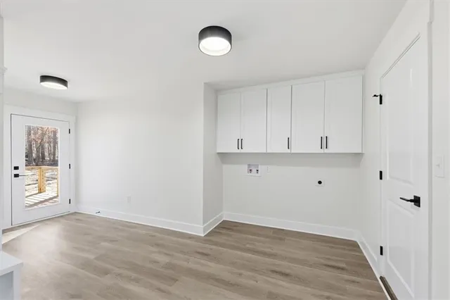 a view of a white house with large windows next to a road
