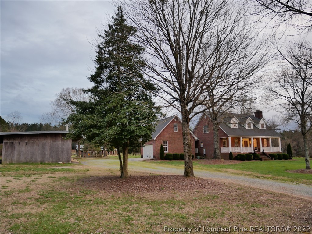 2035 North Moore Road Robbins, NC 27325 - Photo 2 of 16 a front view of a house with a garden and trees