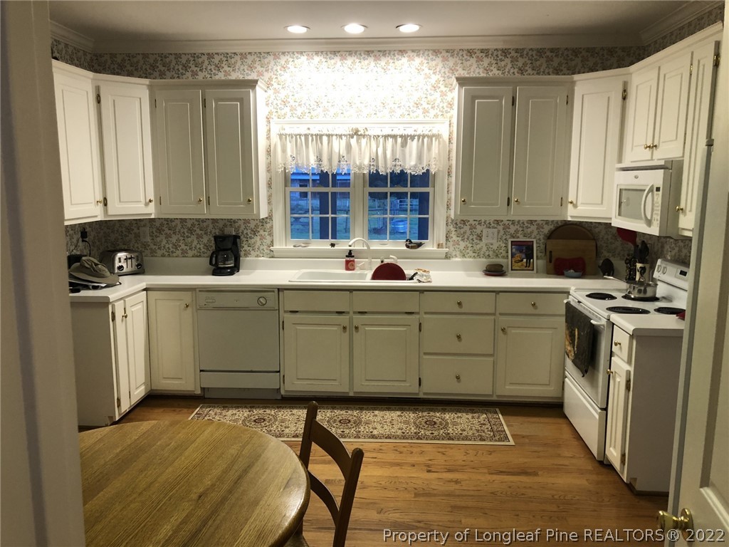 2035 North Moore Road Robbins, NC 27325 - Photo 7 of 16 a kitchen with a sink white cabinets and white appliances