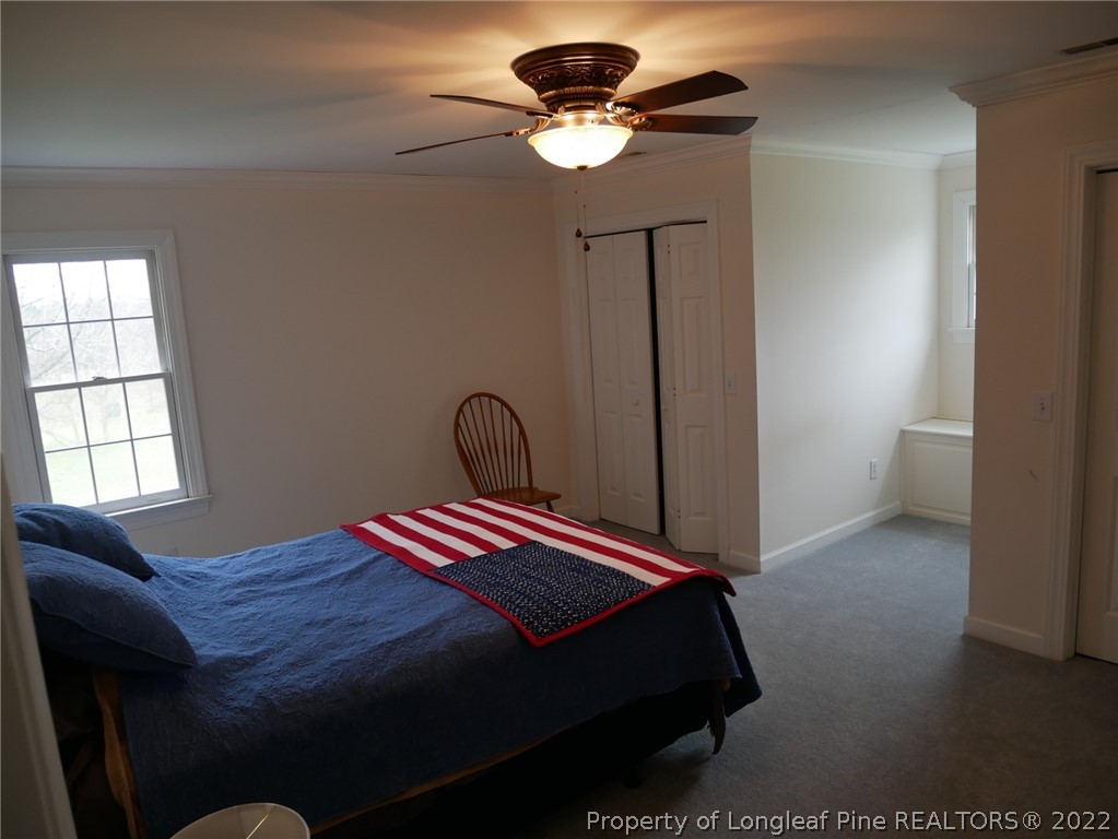 2035 North Moore Road Robbins, NC 27325 - Photo 8 of 16 a bedroom with a bed and a chandelier