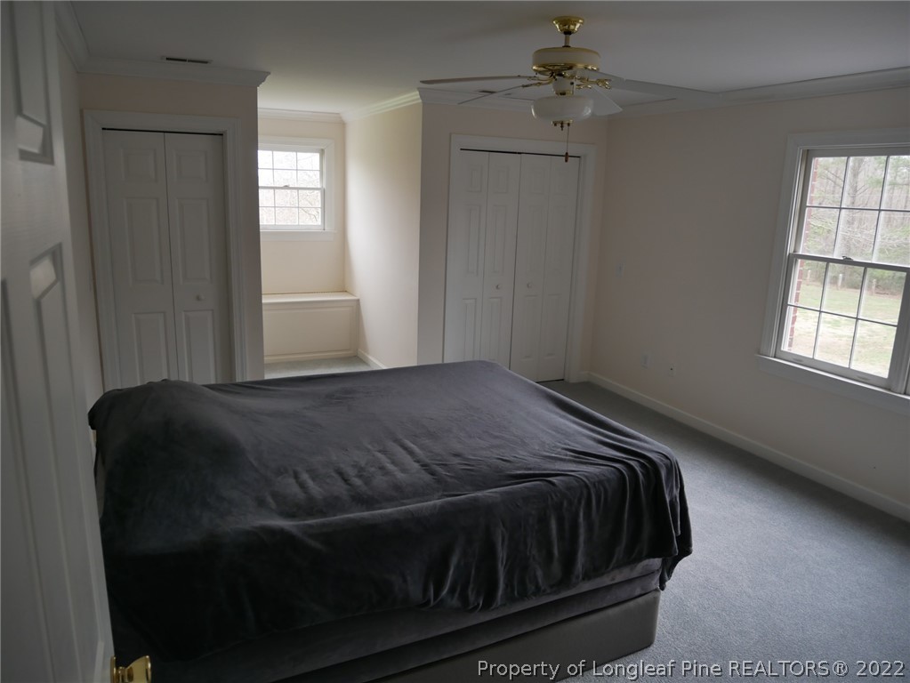 2035 North Moore Road Robbins, NC 27325 - Photo 9 of 16 a bed sitting in a bedroom next to a window and chandelier