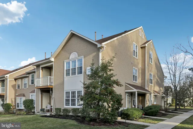 a front view of residential houses with yard and green space