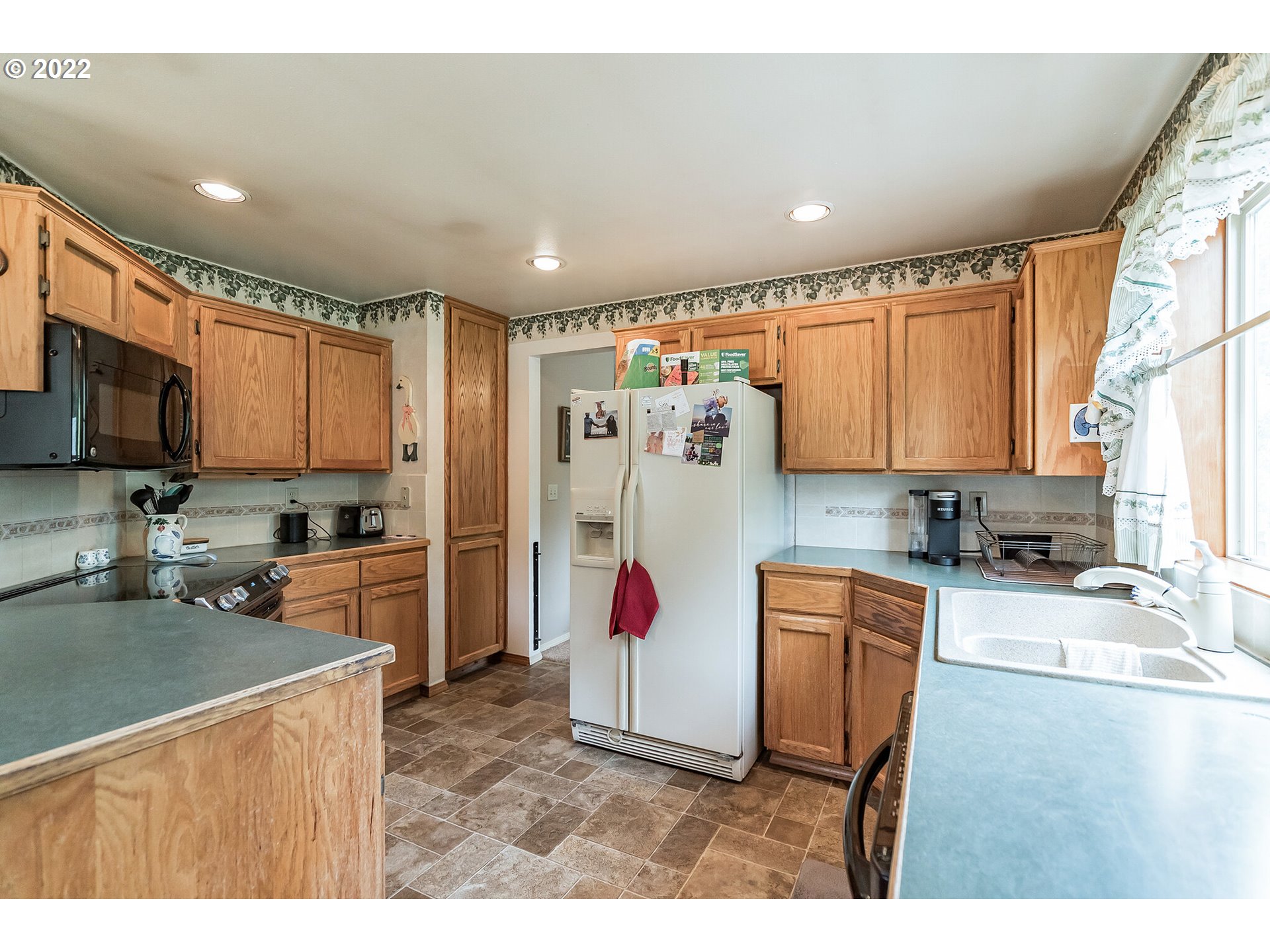 12251 Southeast Winston Road Damascus, OR 97089 - Photo 7 of 32 a kitchen with stainless steel appliances granite countertop a refrigerator sink and microwave