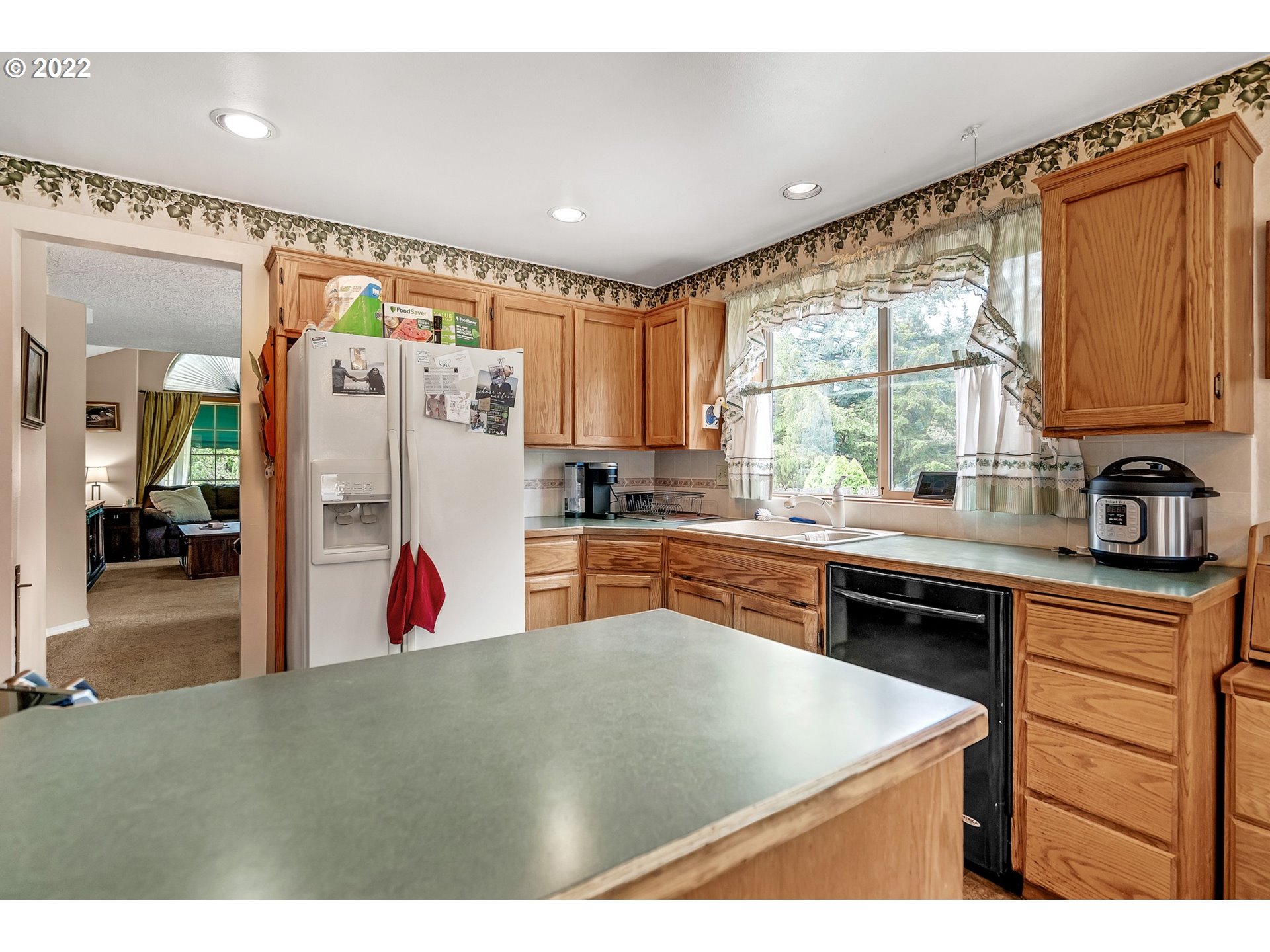 12251 Southeast Winston Road Damascus, OR 97089 - Photo 8 of 32 a kitchen with stainless steel appliances granite countertop a refrigerator a sink dishwasher a stove and white countertops with wooden floor