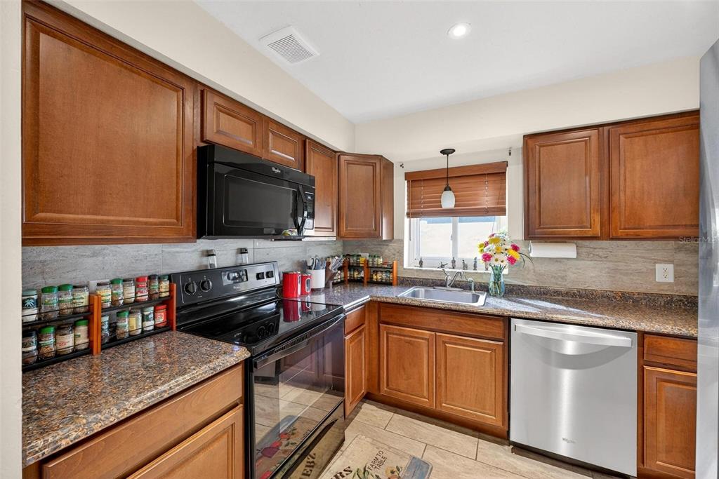 1024 Timor Avenue Orlando, FL 32804 - Photo 14 of 51 a kitchen with stainless steel appliances granite countertop a sink stove and microwave
