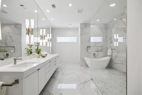 a bathroom with a double vanity sink a mirror and a bathtub