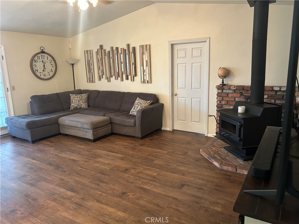 20187 Itasca Road Apple Valley, CA 92308 - Photo 18 of 35 a living room with couches a fireplace and a flat tv screen next to a window