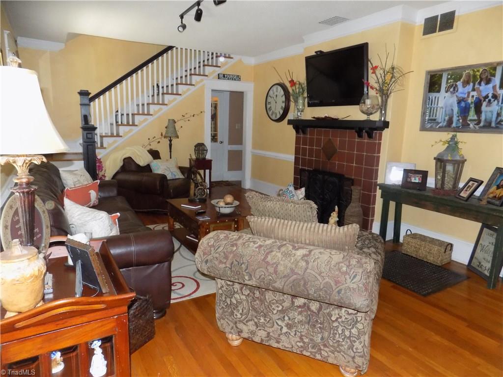 1013 North Hamilton Street High Point, NC 27262 - Photo 5 of 30 Large Family Room with Original Tiling around Fireplace with Gas Log Insert. Television and brackets remain with home. Notice the beautiful hardwood floors.