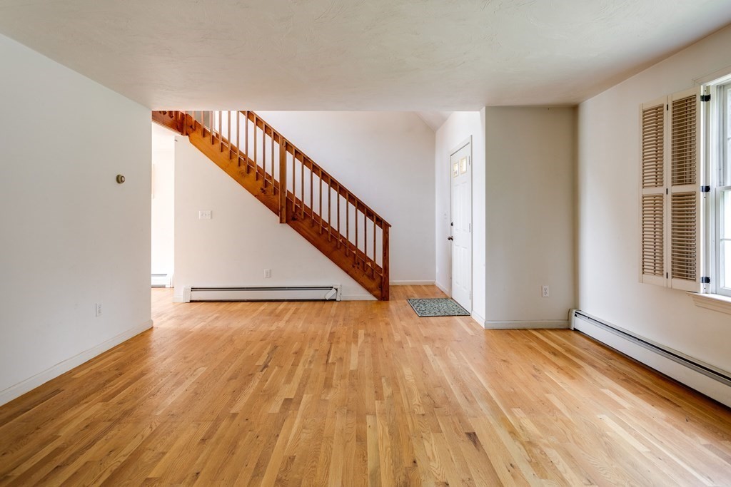 58 Peabody Road, Unit L Shirley, MA 01464 - Photo 3 of 22 a view of an empty room with wooden floor and stairs