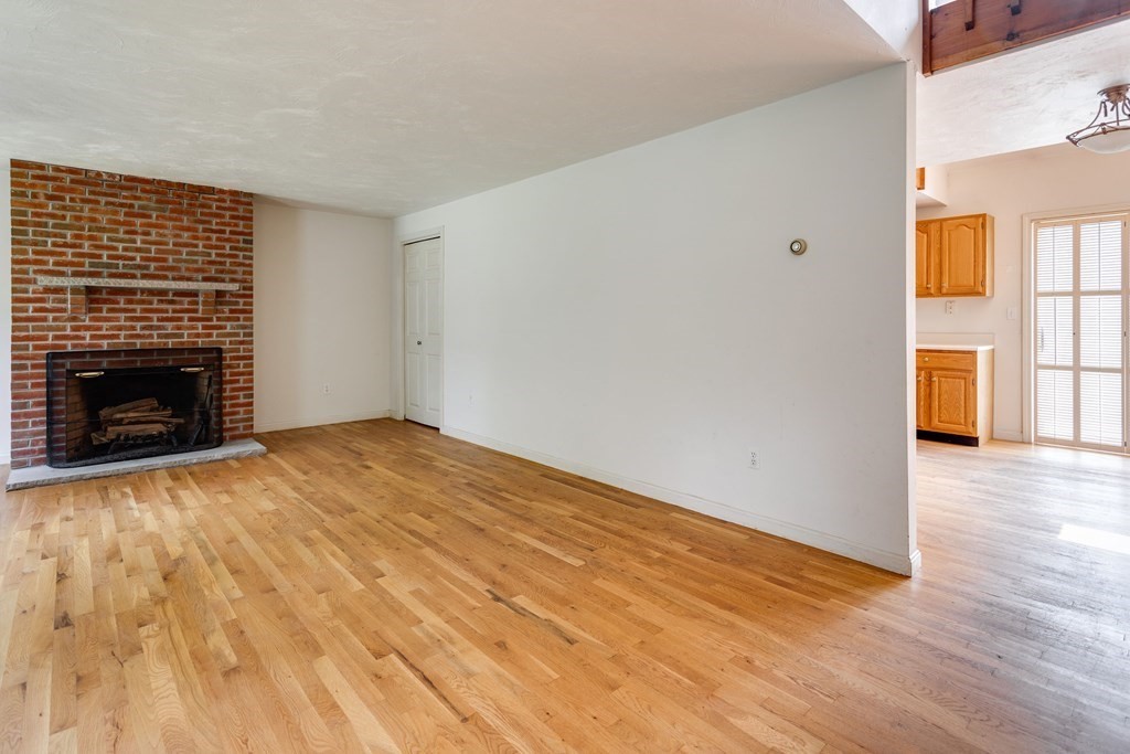 58 Peabody Road, Unit L Shirley, MA 01464 - Photo 5 of 22 a view of empty room with wooden floor and fireplace