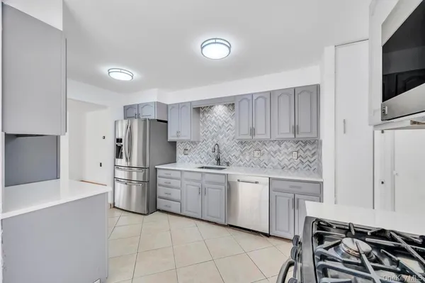 a kitchen with stainless steel appliances a refrigerator sink and cabinets