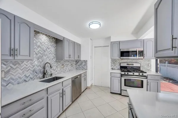 a kitchen with stainless steel appliances granite countertop a sink stove oven and refrigerator