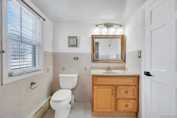 a bathroom with a toilet a sink and mirror