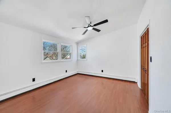 an empty room with a window and ceiling fan