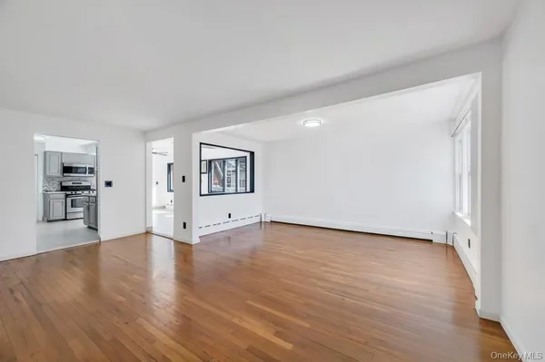 a view of a big room with wooden floor and a kitchen