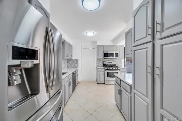 a kitchen with stainless steel appliances granite countertop a refrigerator stove and sink