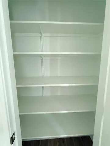 a view of walk in closet with empty racks