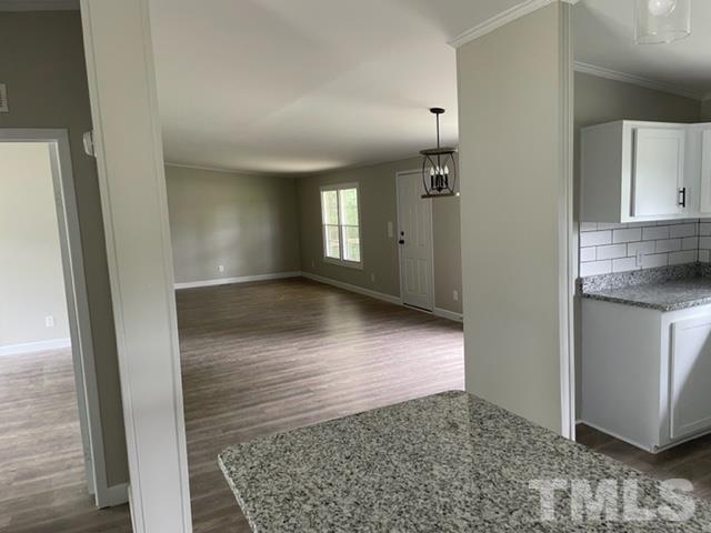 860 Thanksgiving Fire Road Selma, NC 27576 - Photo 13 of 23 a view of a hallway with wooden floor and a living room
