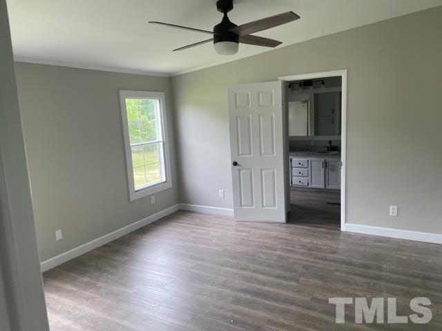 860 Thanksgiving Fire Road Selma, NC 27576 - Photo 17 of 23 an empty room with wooden floor cabinet and windows