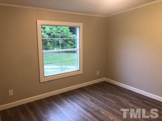 860 Thanksgiving Fire Road Selma, NC 27576 - Photo 21 of 23 an empty room with wooden floor and windows
