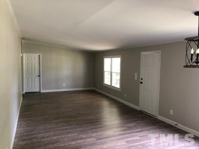860 Thanksgiving Fire Road Selma, NC 27576 - Photo 8 of 23 an empty room with wooden floor and windows