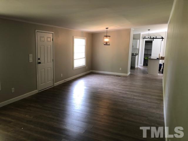 860 Thanksgiving Fire Road Selma, NC 27576 - Photo 9 of 23 an empty room with wooden floor and windows