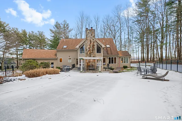a view of a house with wooden bench in front of house