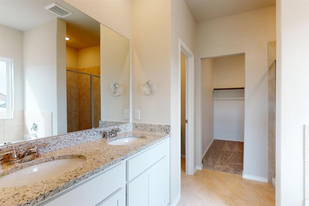 4509 Beacon Bay Drive Austin, TX 78747 - Photo 12 of 30 Bathroom featuring a spacious closet, a stall shower, and double vanity