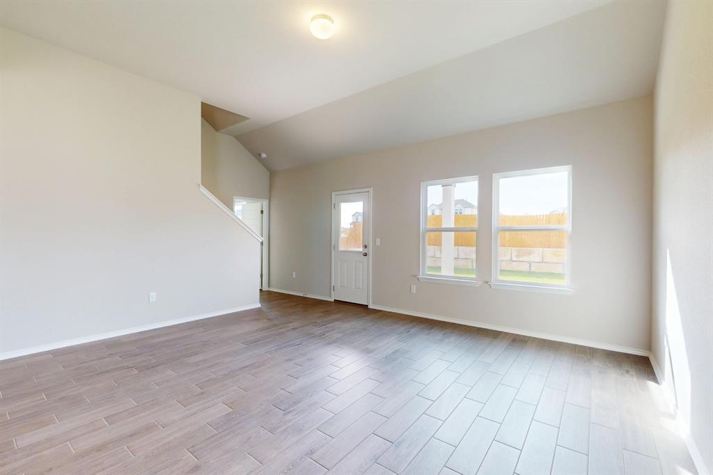4509 Beacon Bay Drive Austin, TX 78747 - Photo 6 of 30 Unfurnished living room featuring wood finish floors and vaulted ceiling