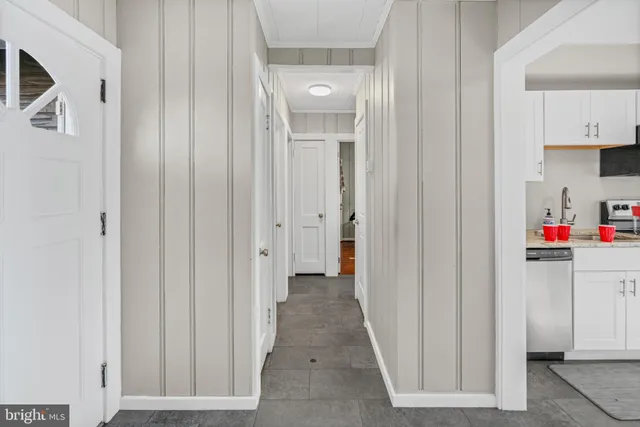 a view of a hallway with white cabinets