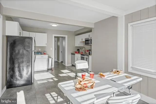 a living room with furniture and a refrigerator