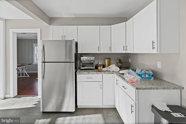 a kitchen with refrigerator and cabinets