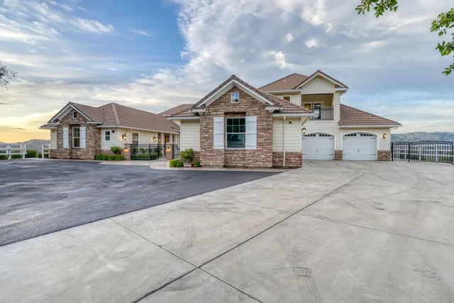 a view of a house with a yard and a large trees