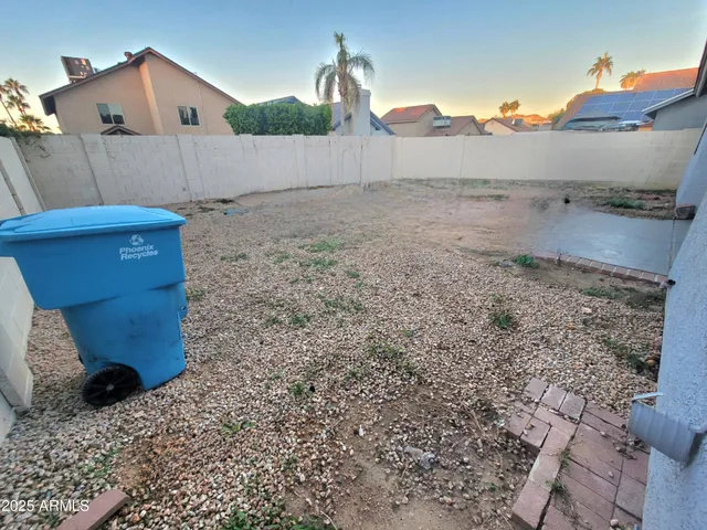 a view of a dry yard with wooden fence